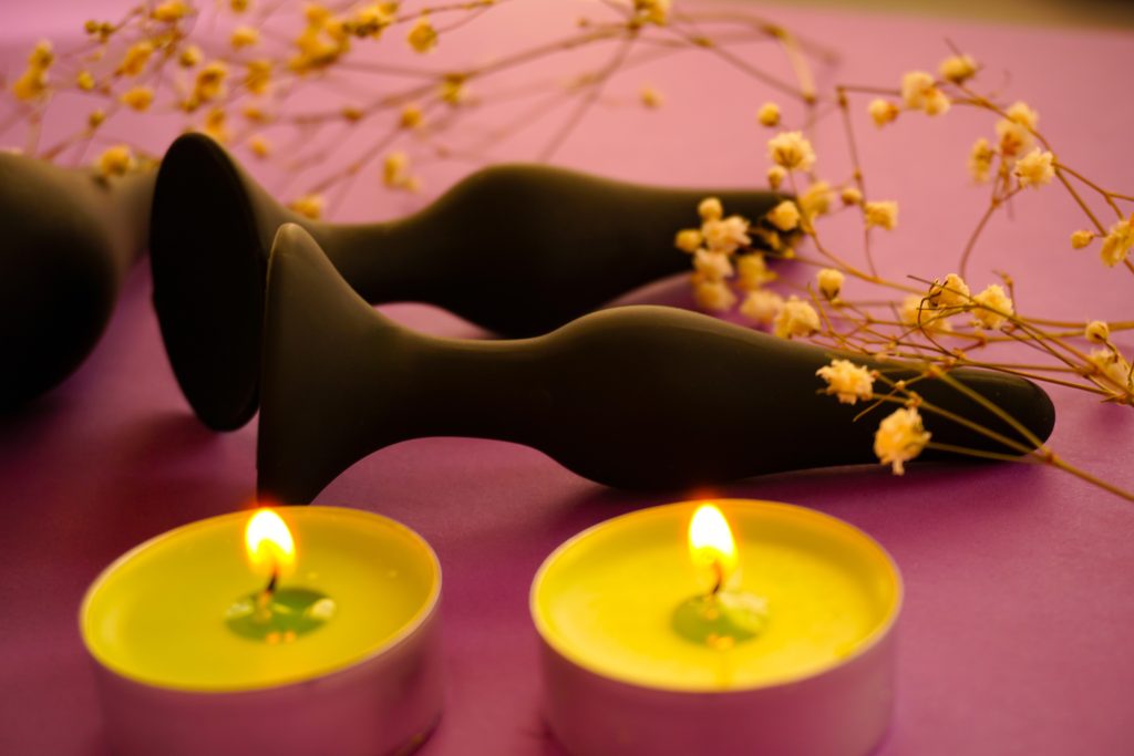 Black Anal Plugs surrounded by candles
